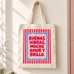 Tote bag de algodón con rayas rosas y rojas, marco azul y la frase Buenas vibras, mucho amor y brillo.