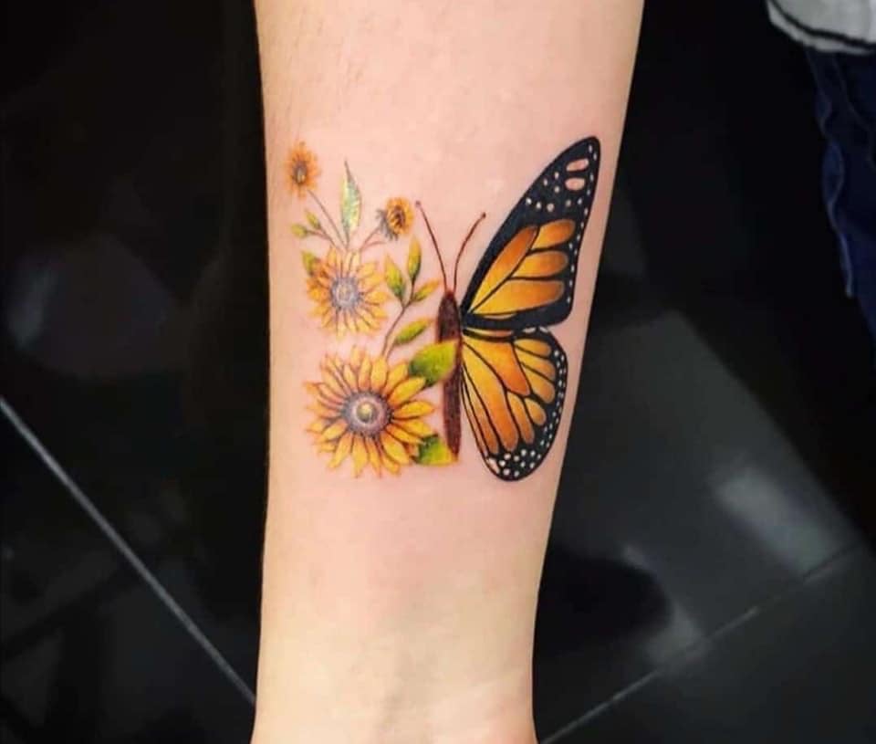 Tatuaje brazo mariposa con la flor que mira al sol