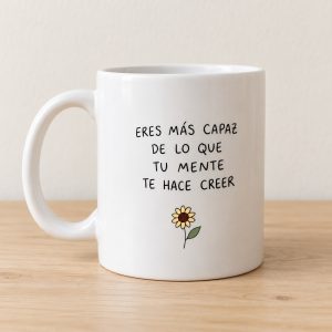 Taza Eres más capaz de lo que tu mente te hace creer. El texto negro y el pequeño girasol mantienen el diseño despejado.